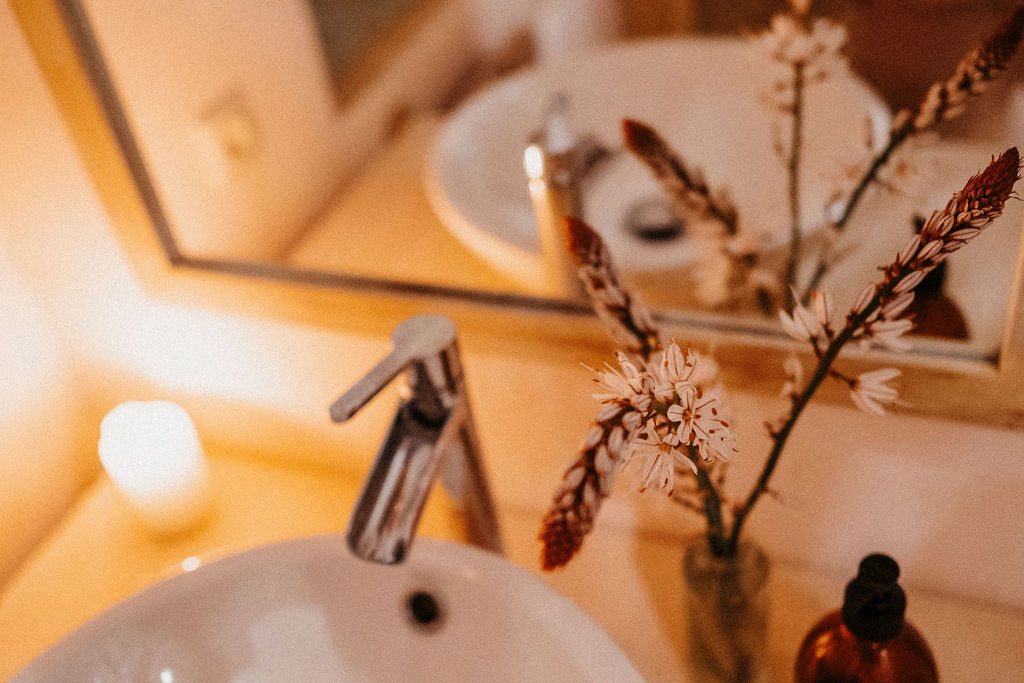 Waschbecken mit Kerze und Blumen