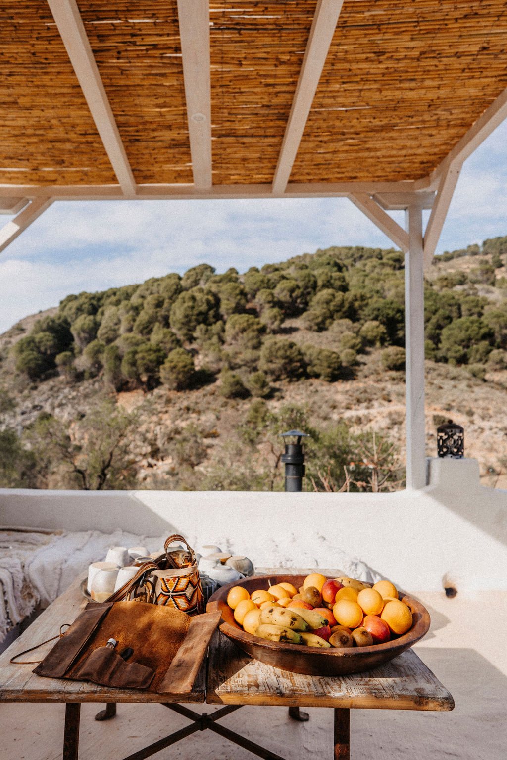 Terrasse mit Obstschale und Blick über die bewaldeten Hügel