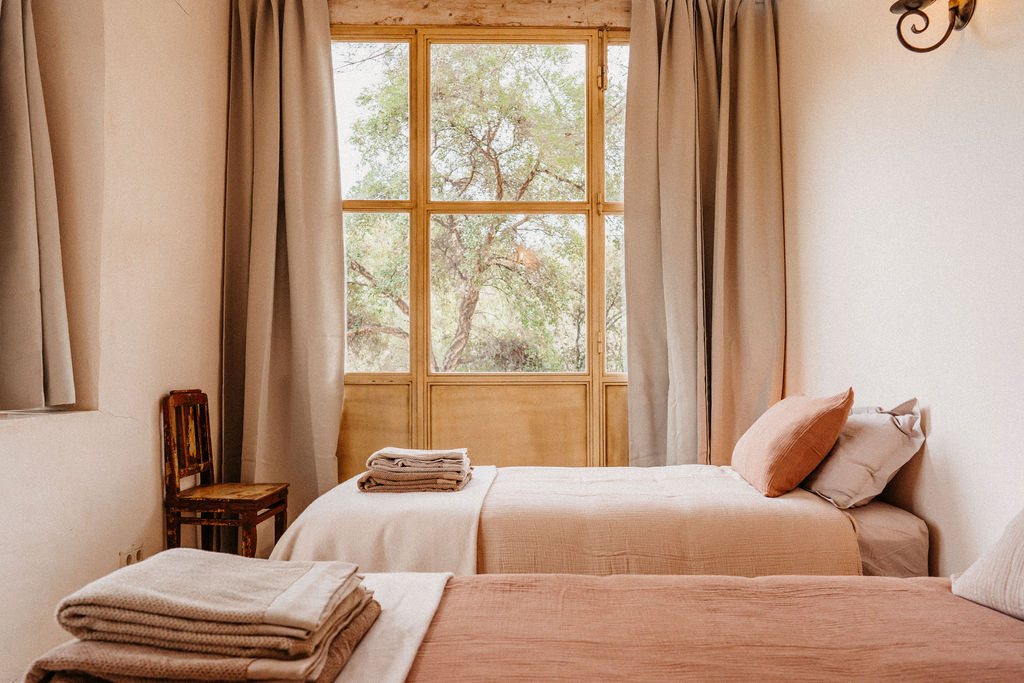 Zimmer mit zwei Betten und Fenster in den Garten