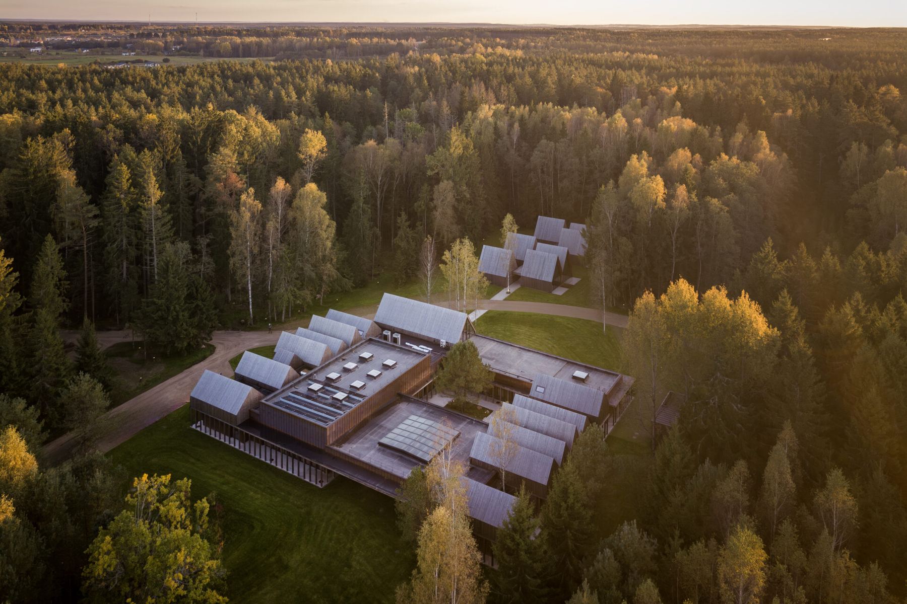 Luftbild: das Sanctum auf einer Lichtung, ringsum Wald bis zum Horizont